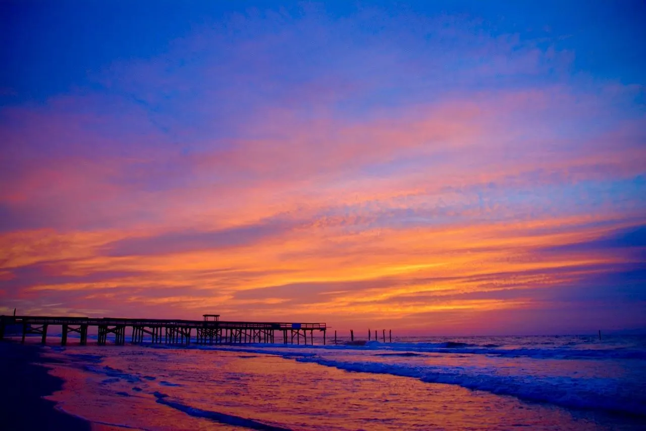 Pier under a pink and purple sunset sky