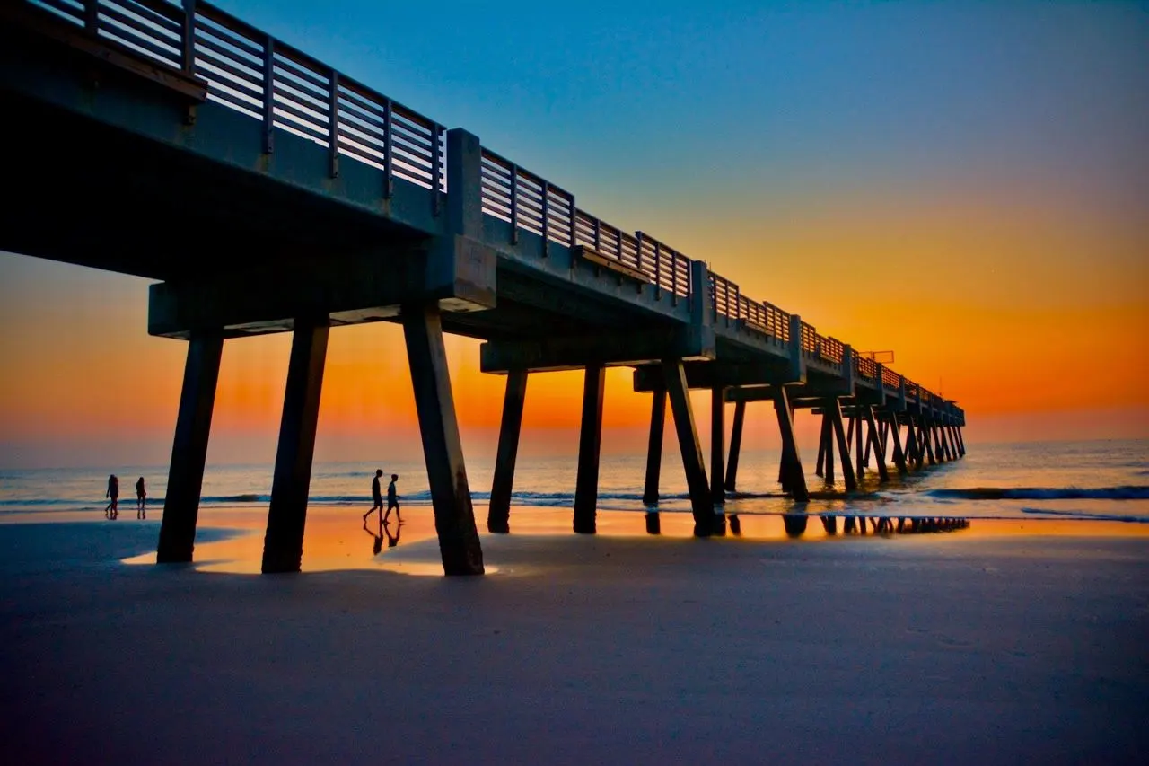 Pier silhouetted against an orange sunrise